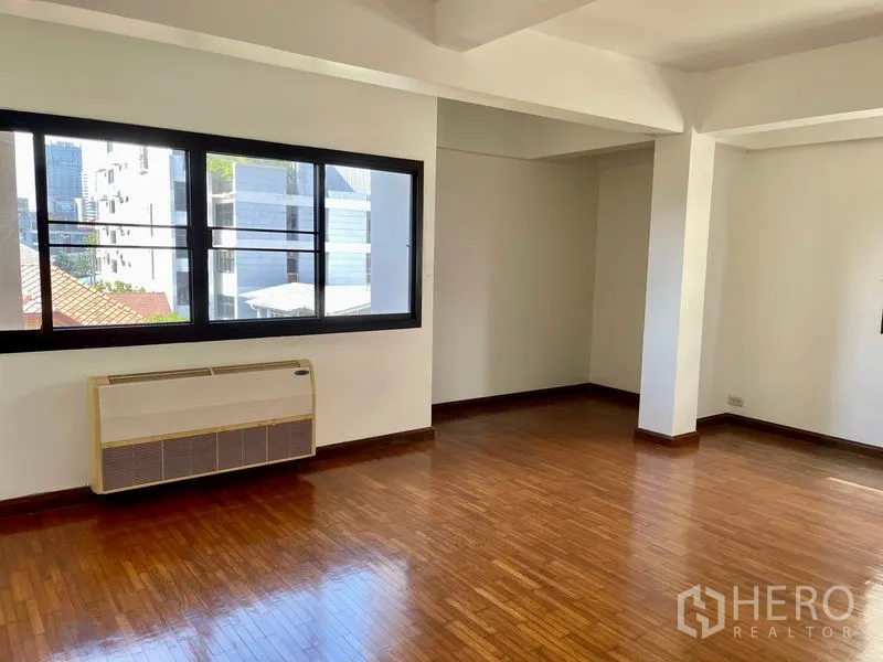 带办公室的家 出租在Khlong Toei, Bangkok - 转角办公空间，宽幅窗户与人字形木地板，可见城市景观。