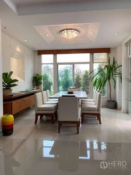 Detached House for rent in Lat Krabang, Bangkok - Dining area with chandelier and floor-to-ceiling windows opening to the garden.