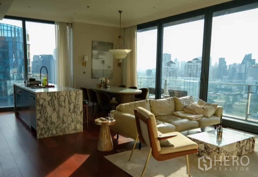 Condominium for rent or sale in Watthana, Bangkok - Open-plan living room with marble island kitchen and skyline views.