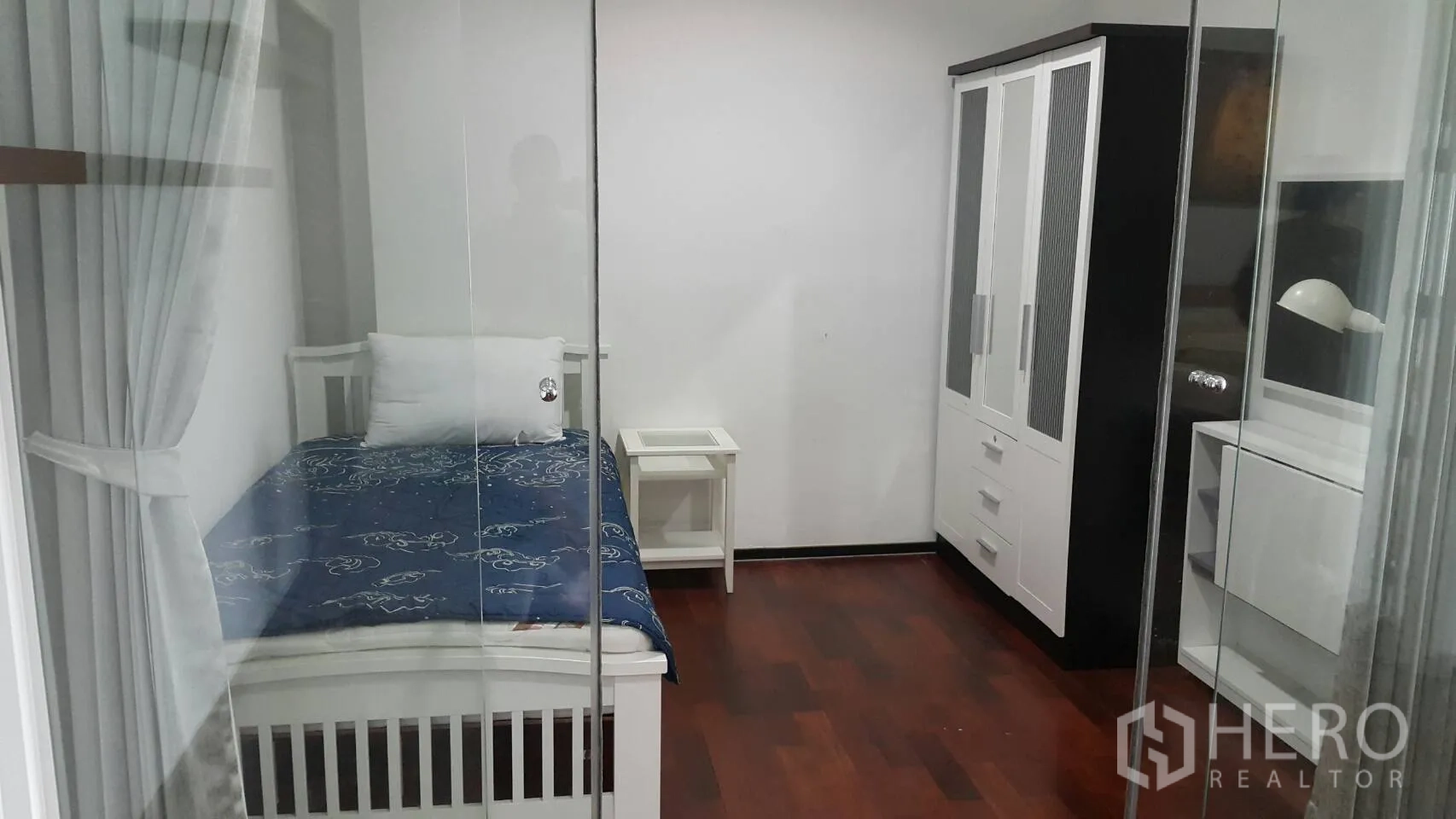 公寓 出租在Watthana, Bangkok - 次卧设单人床、白色衣柜与玻璃推拉门。
