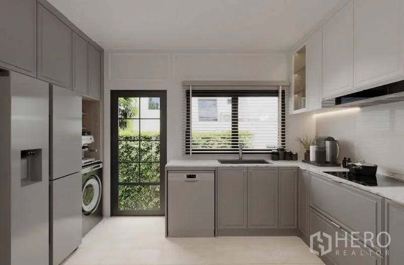 Detached House for rent in Bang Phli, Samut Prakan - Kitchen with window and garden view, integrated appliances and side door.