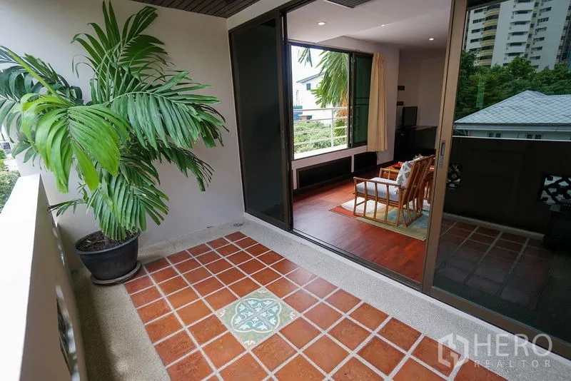 Apartment for rent in Watthana, Bangkok - Private bedroom balcony with terracotta tiles next to full-height sliding doors.