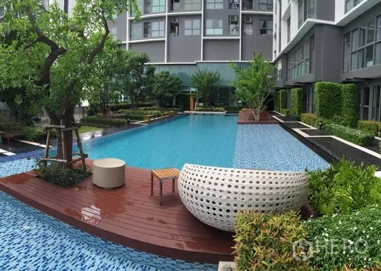 Condominium for rent in Phra Khanong, Bangkok - Resort-style swimming pool with deck seating and lush landscaping at a modern Bangkok condominium.