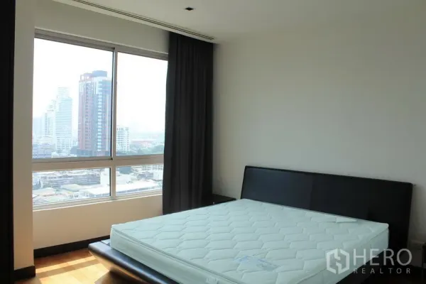 คอนโด ให้เช่าหรือขายในYan Nawa, Bangkok - ห้องนอนมีหน้าต่างบานใหญ่ ม่านทึบ เตียงเตี้ย พร้อมวิวเมือง