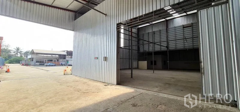 货栈 出租在Pak Kret, Nonthaburi - 暖武里府Pak Kret金属板仓库，超宽滑门与前方装卸院区。