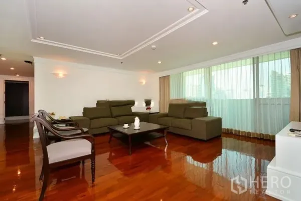 Apartment for rent in Khlong Toei, Bangkok - Bright living room with large windows, sheer curtains, recessed lighting and polished hardwood floors.