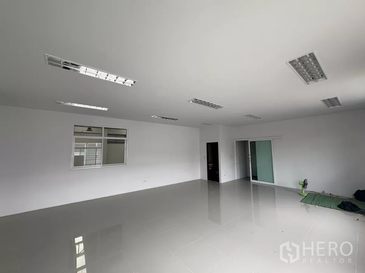 Factory for rent in Phra Samut Chedi, Samut Prakan - Large office room with sliding glass door and recessed fluorescent lighting.