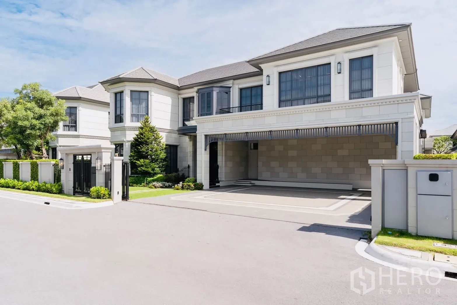 Detached House for rent or sale in Bang Kapi, Bangkok - Corner view of a modern two-storey detached house with driveway and garden.