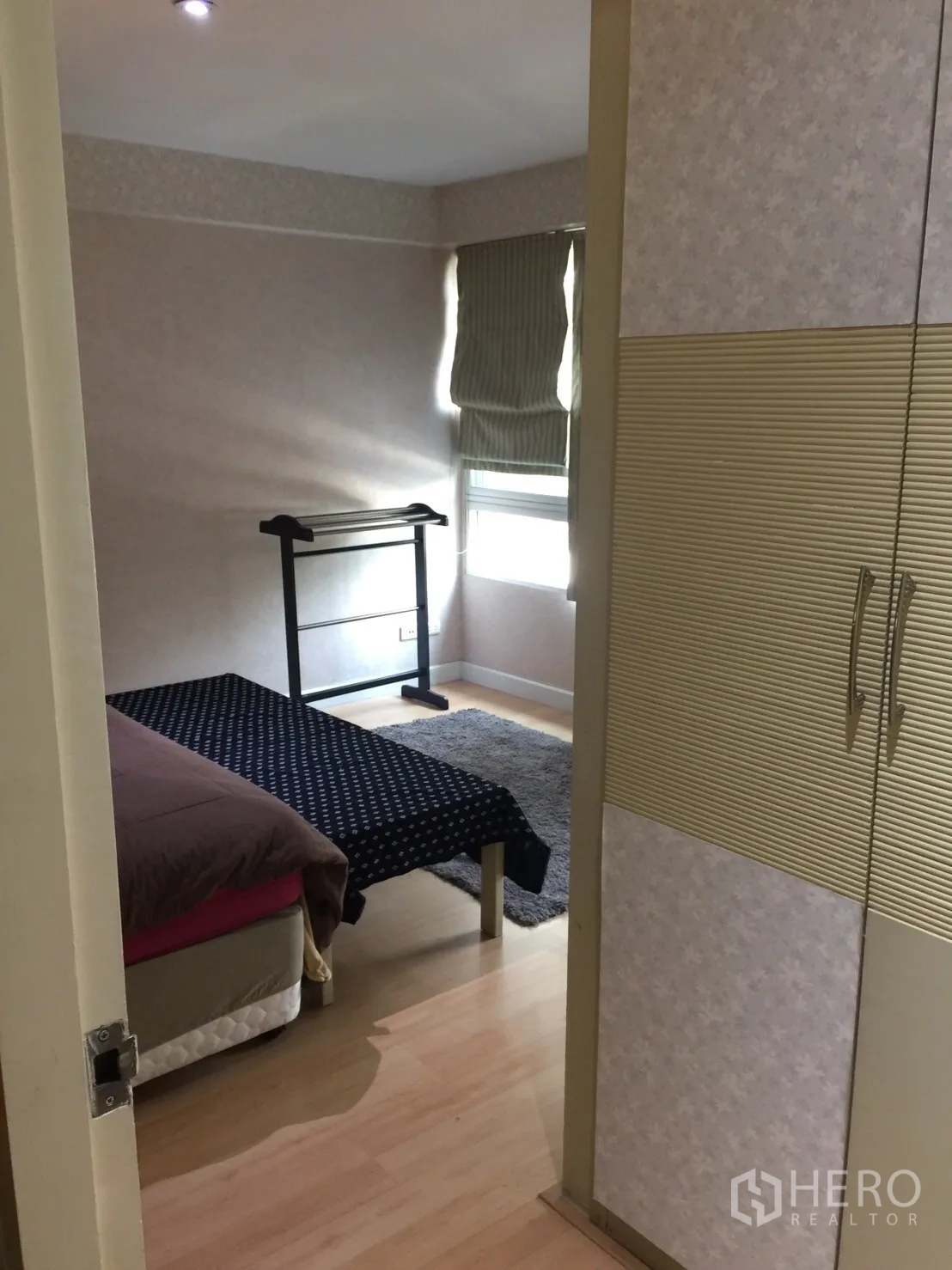 Condominium for rent in Khlong Toei, Bangkok - Second bedroom with wardrobe, window shades, small bed, and light wood flooring.