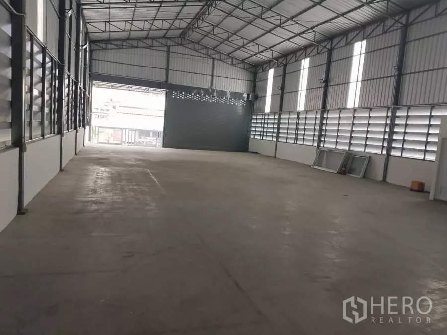 货栈 出租在Huai Khwang, Bangkok - 宽敞仓库内部，高挑人字形屋顶与百叶通风窗，朝向前门。