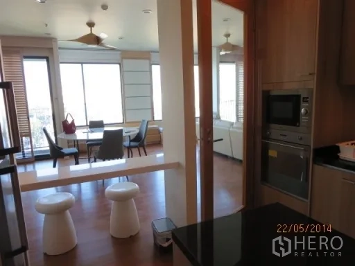 Condominium for rent in Bang Rak, Bangkok - View from the kitchen to a bright dining and living area with large windows.