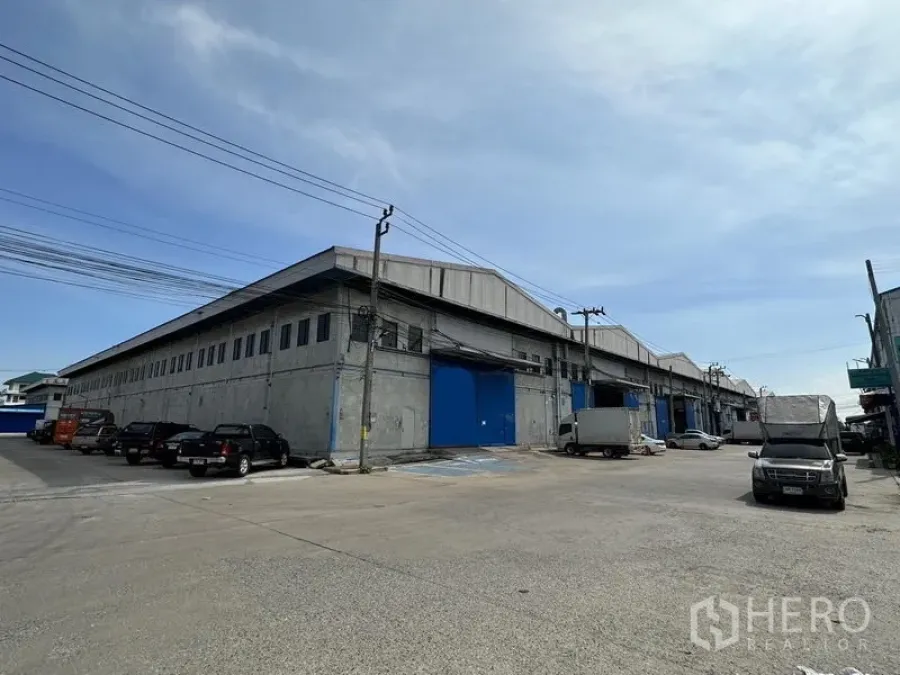 คลังสินค้า ให้เช่าในBang Phli, Samut Prakan - มุมอาคารโกดังคอนกรีตขนาดใหญ่ ประตูโหลดสินค้าโทนสีน้ำเงินและลานรถกว้าง ย่านบางพลี สมุทรปราการ