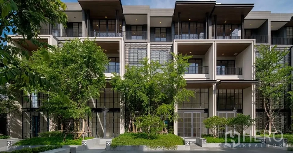 ทาวน์เฮาส์ for rent or sale in Watthana, Bangkok - ด้านหน้าทาวน์เฮ้าส์สมัยใหม่พร้อมระเบียงและสวนร่มรื่น