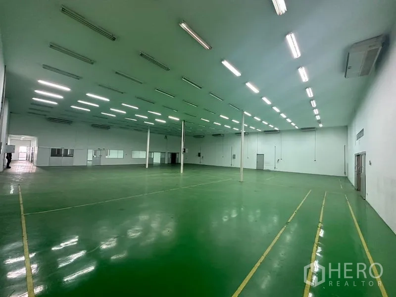 Warehouse for rent in Suan Luang, Bangkok - Air-conditioned warehouse hall with high ceiling, columns, and green epoxy floor.
