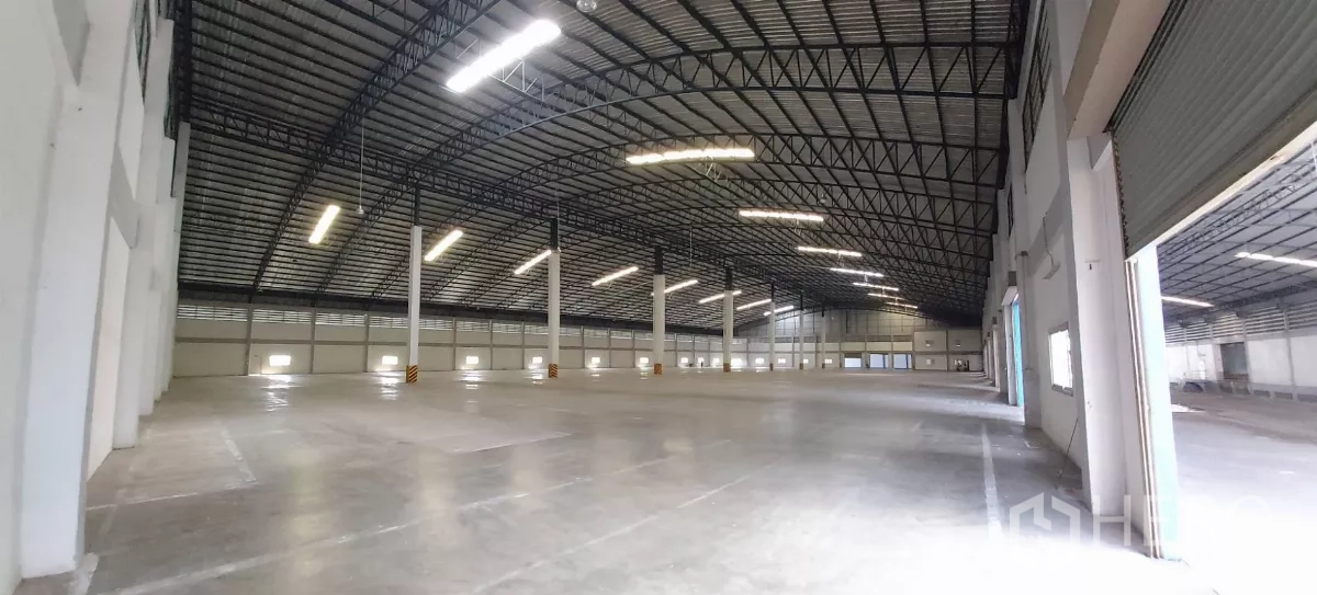 Warehouse for rent in Bang Bo, Samut Prakan - Interior view toward open roller doors along the warehouse side wall.