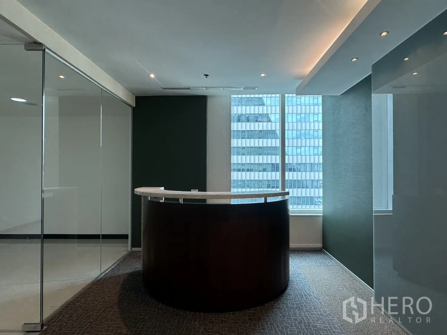 Office Space for rent in Watthana, Bangkok - Reception lobby with a curved counter between glass partitions and a windowed backdrop.
