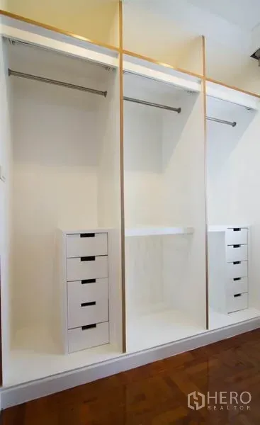 Condominium for rent in Watthana, Bangkok - Built-in white wardrobes with hanging rails and drawers in a spacious condo.