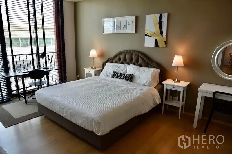Condominium for rent in Phaya Thai, Bangkok - Spacious bedroom with king bed, twin nightstands, and large windows with blinds in Phaya Thai condo.