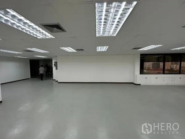 办公空间 出租在Watthana, Bangkok - 开放办公区，白色墙面、嵌入式灯光、转角窗景与内置收纳柜。