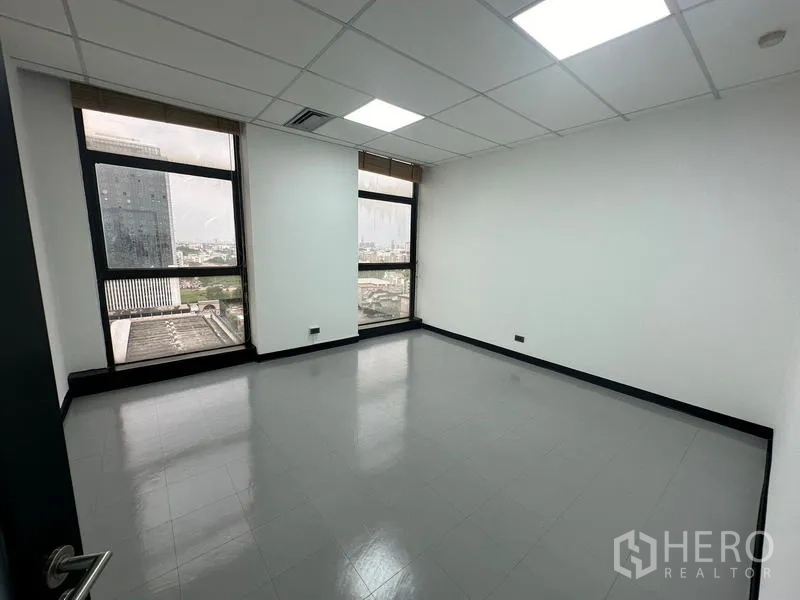 Office Space for rent - Private office room with two tall windows offering wide Bangkok city views.