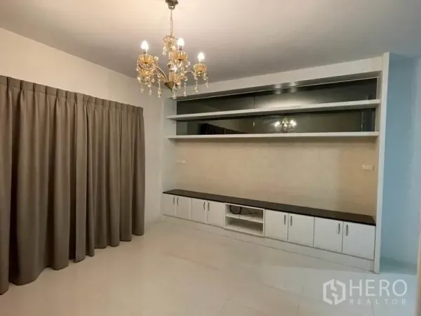 Detached House for sale in Khlong Toei, Bangkok - Living room featuring chandelier lighting and a built-in TV wall cabinet.