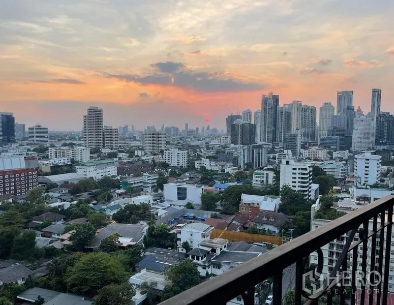 Condominium for sale in Khlong Toei, Bangkok - Panoramic Bangkok skyline at sunset from a high-floor balcony.