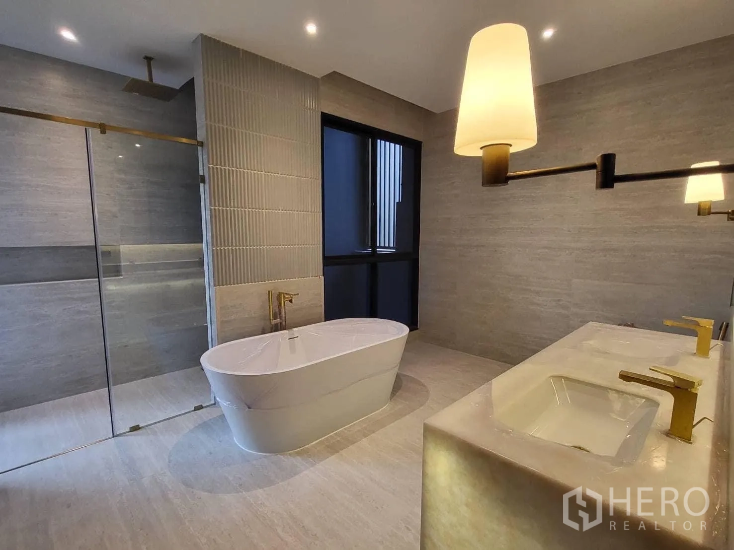 Detached House for rent - Bathroom with rain shower enclosure, freestanding tub and twin sinks with gold fixtures.