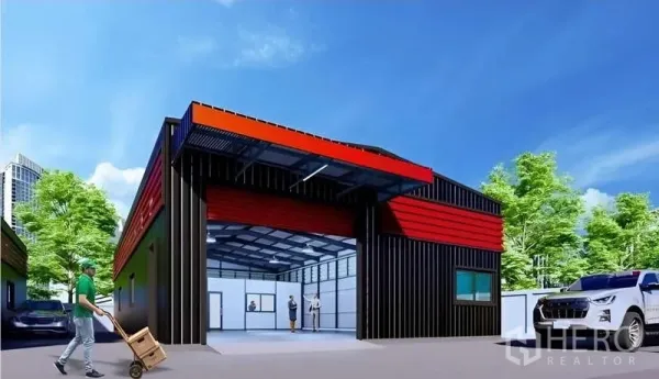 Warehouse for rent in Lat Phrao, Bangkok - Front view of the warehouse loading bay with open entrance, parking area, and greenery around the site.