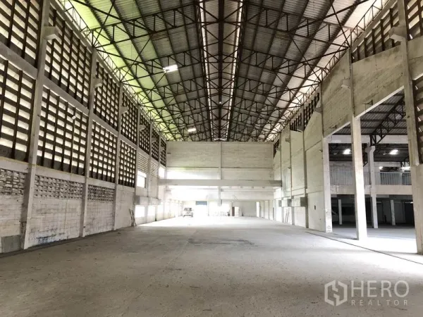 Factory for rent in Lam Luk Ka, Pathum Thani - Expansive warehouse interior with high steel‑truss roof and ventilated block walls.