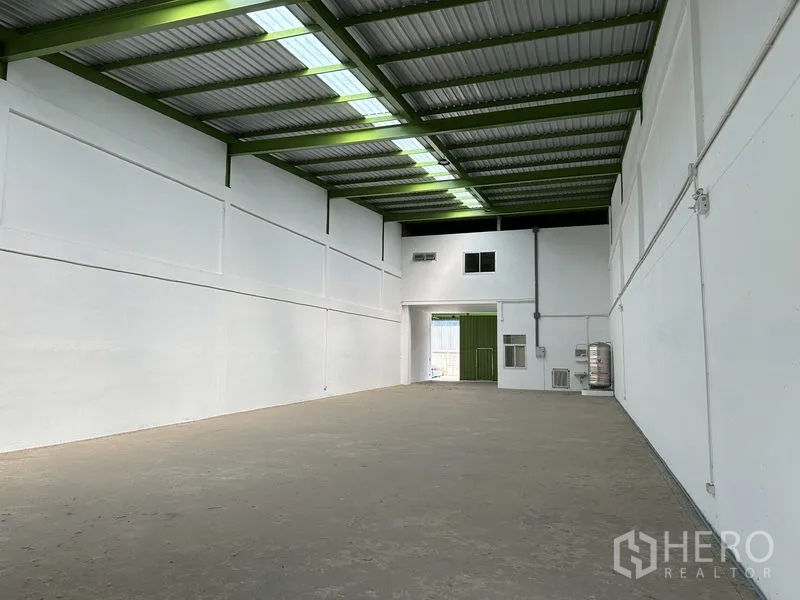 货栈 出租在Pathum Thani - 从仓库内部望向主入口，高挑空间与透光屋面板带来自然采光。