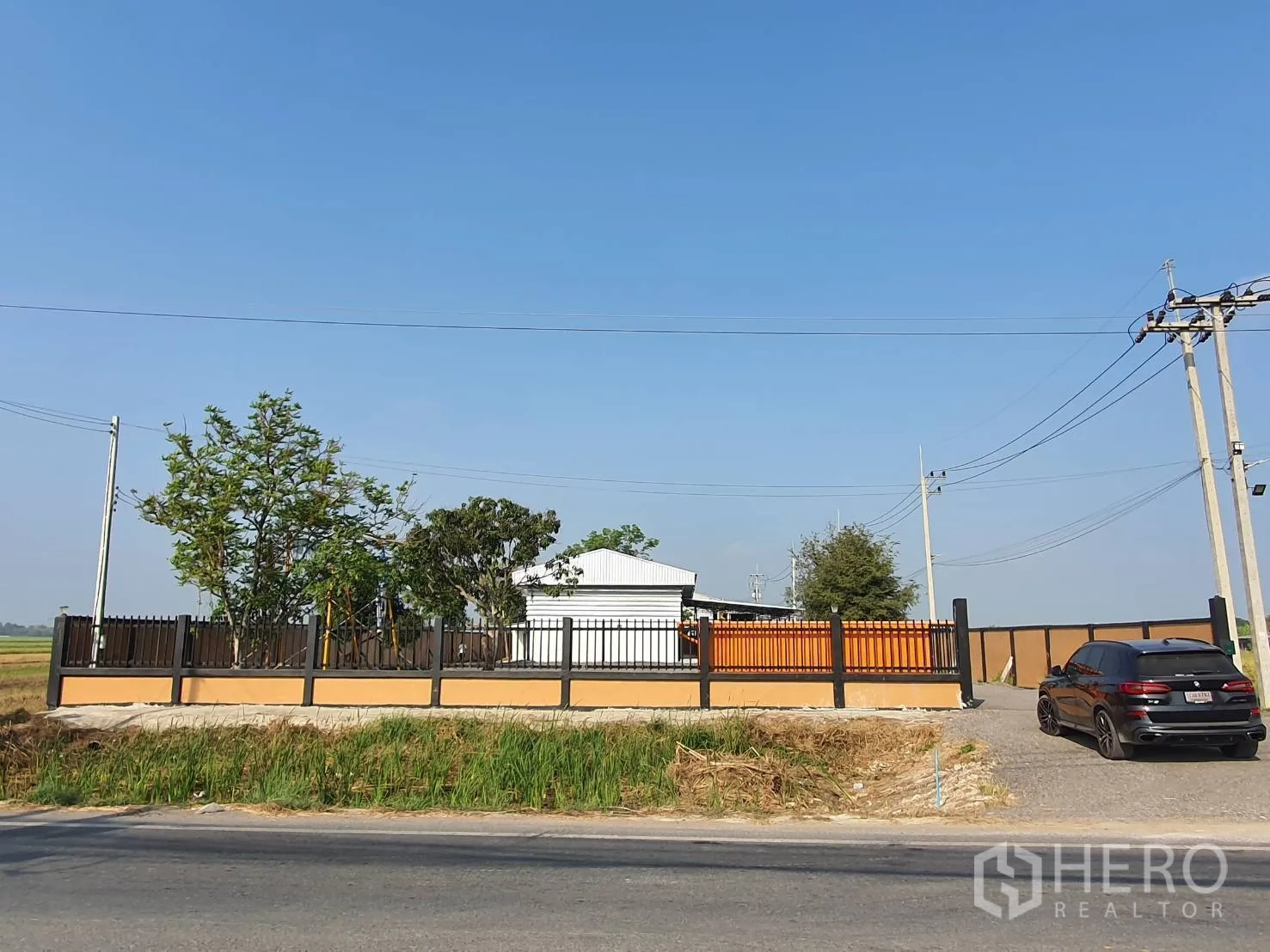 โกดัง for sale in Lam Luk Ka, Pathum Thani - แนวรั้วและประตูหน้า หันสู่ถนนลาดยางสาธารณะ