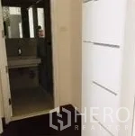 Condominium for rent in Watthana, Bangkok - Hallway with built-in white storage leading toward the bathroom.