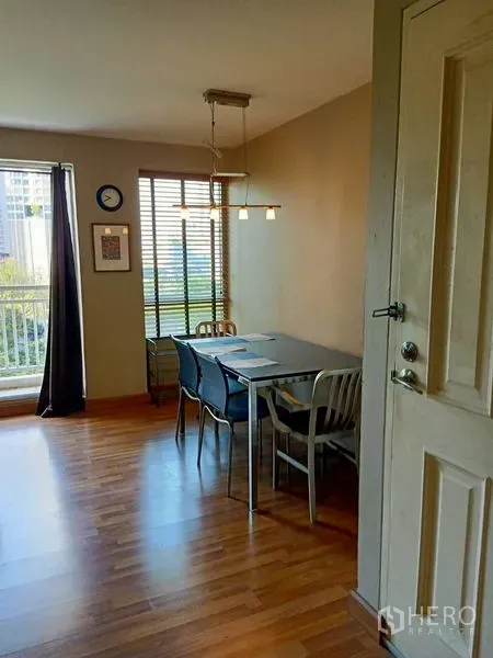 Condominium for rent in Khlong Toei, Bangkok - Bright dining corner with pendant light, blinds and a four-seat table on wood flooring.