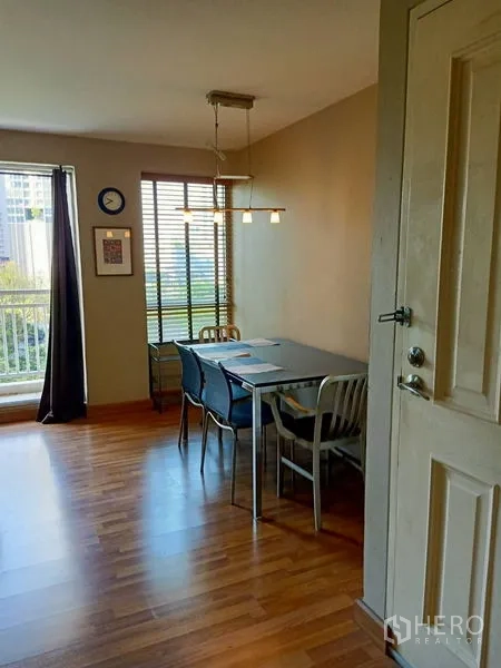 Condominium for rent in Khlong Toei, Bangkok - Bright dining corner with pendant light, blinds and a four-seat table on wood flooring.