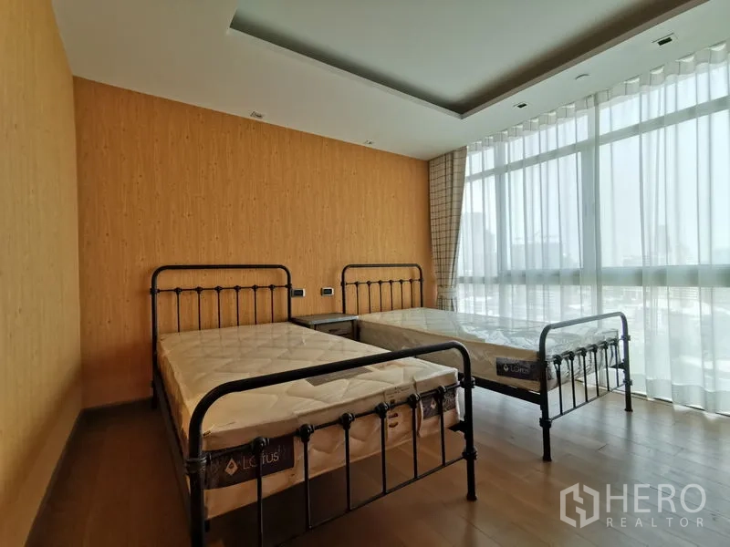 Condominium for rent or sale in Phaya Thai, Bangkok - Twin bedroom with two metal-frame beds and panoramic floor-to-ceiling windows.