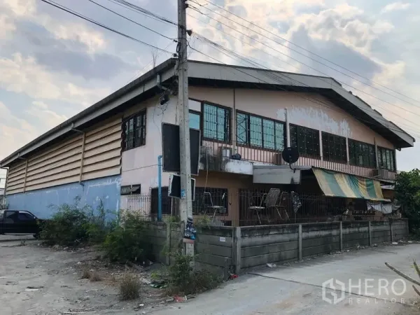 คลังสินค้า ให้เช่าในNonthaburi - ด้านข้าง–ด้านหลังอาคารชั้นสองมีหน้าต่างยาว ระเบียงเล็ก และกำแพงรั้ว