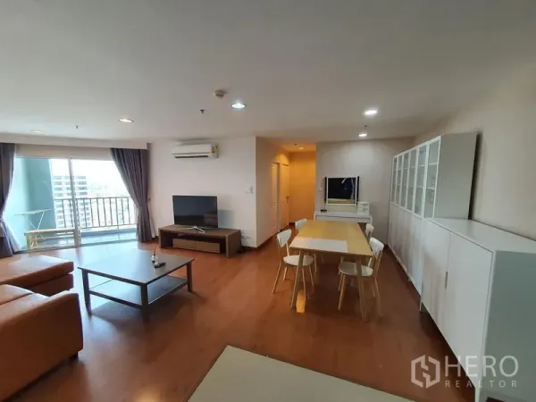 คอนโด ให้เช่าในHuai Khwang, Bangkok - พื้นที่นั่งเล่นและรับประทานอาหารแบบโอเพ่น มีตู้โชว์ ทีวี และทางออกสู่ระเบียง ในคอนโดใกล้ MRT พระราม 9