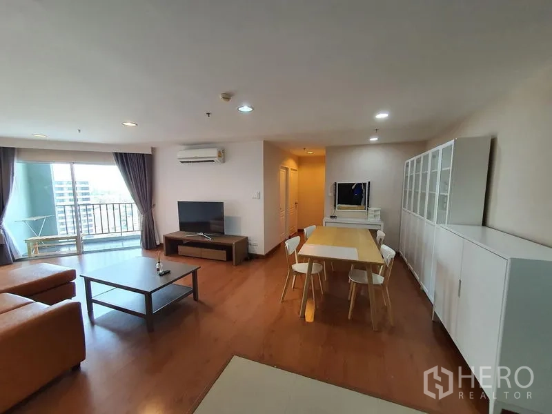 คอนโด ให้เช่าในHuai Khwang, Bangkok - พื้นที่นั่งเล่นและรับประทานอาหารแบบโอเพ่น มีตู้โชว์ ทีวี และทางออกสู่ระเบียง ในคอนโดใกล้ MRT พระราม 9