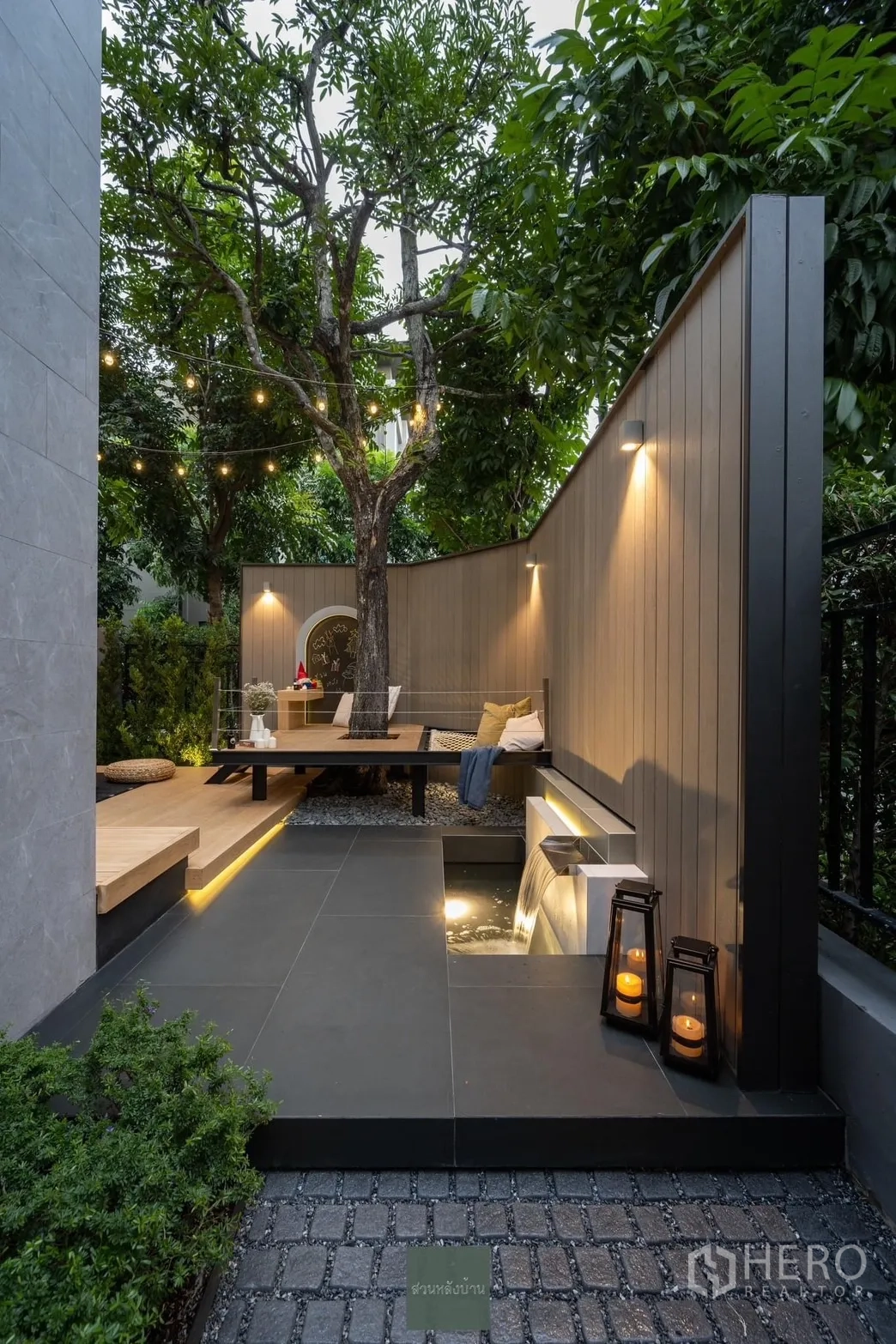 Detached House for rent or sale in Phra Khanong, Bangkok - Landscaped private garden with mature tree, bench seating, wall lights and a water feature.
