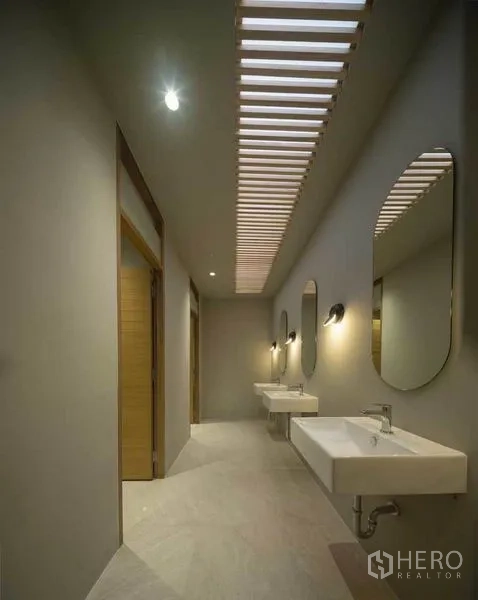 带办公室的家 出售在Wang Thonglang, Bangkok - 走道洗手区，格栅天窗、墙壁灯与多面镜子及台盆。