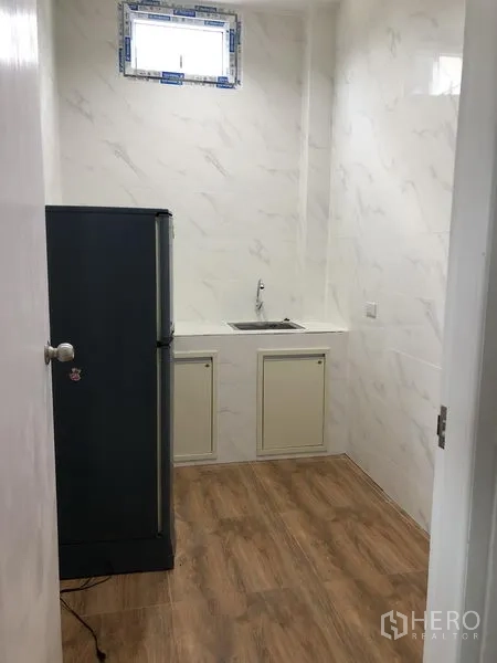 Factory for rent in Samut Prakan - Compact pantry with sink, cabinets and refrigerator.