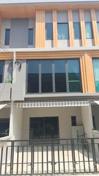 联排别墅 出租 - 曼谷Prawet三层现代联排别墅外观，带院内车位、大窗与条纹遮阳篷。