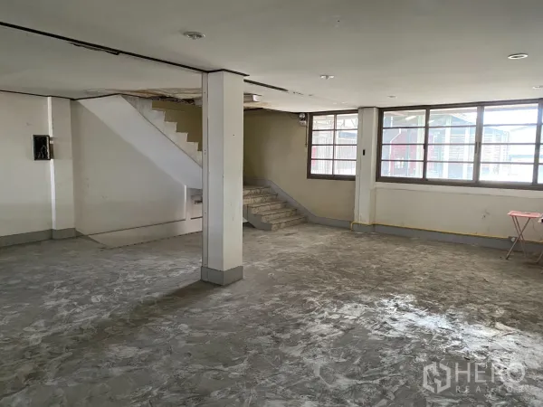 Retail Space for rent in Yan Nawa, Bangkok - Spacious upper-floor area with staircase, large windows and polished concrete floor.