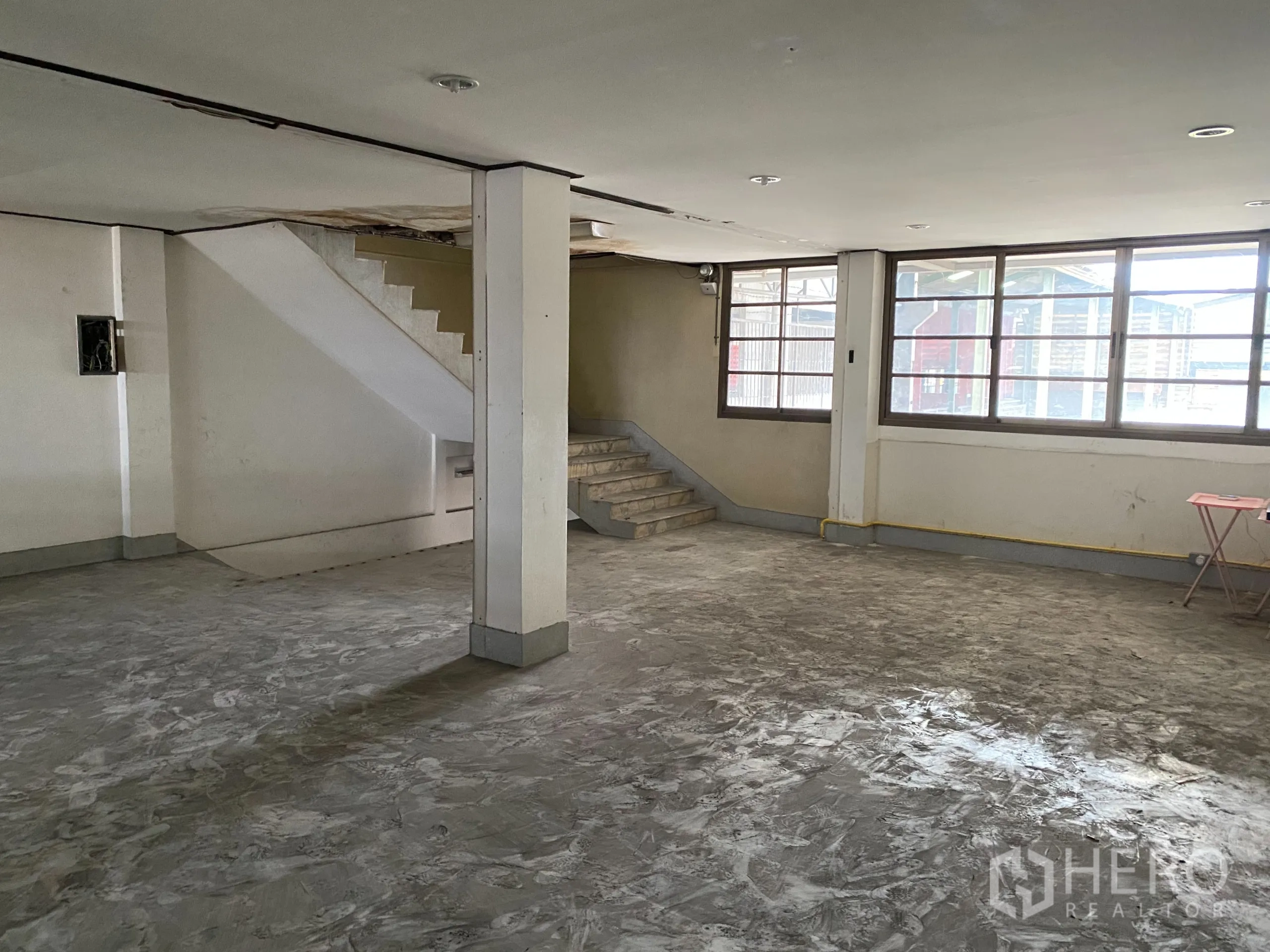 Retail Space for rent in Yan Nawa, Bangkok - Spacious upper-floor area with staircase, large windows and polished concrete floor.