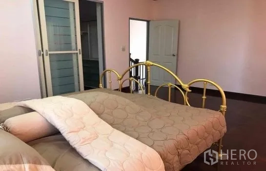 独立式住宅 出租在Khlong Sam Wa, Bangkok - 主卧室，金色金属床架，粉色墙面，推拉衣柜门