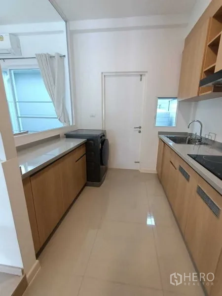 联排别墅 出租在Prawet, Bangkok - 厨房另一角度，长台面、水槽与洗衣机一应俱全。