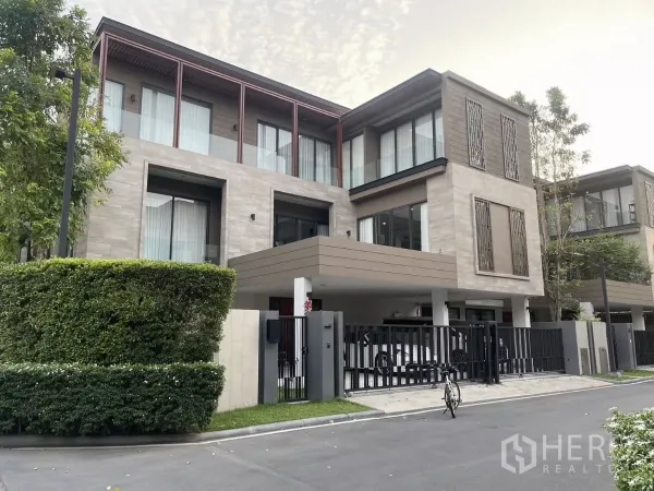 Detached House for rent or sale in Bang Kapi, Bangkok - Modern three-storey detached house facade with gated driveway, hedges and covered carport in Bang Kapi, Bangkok.