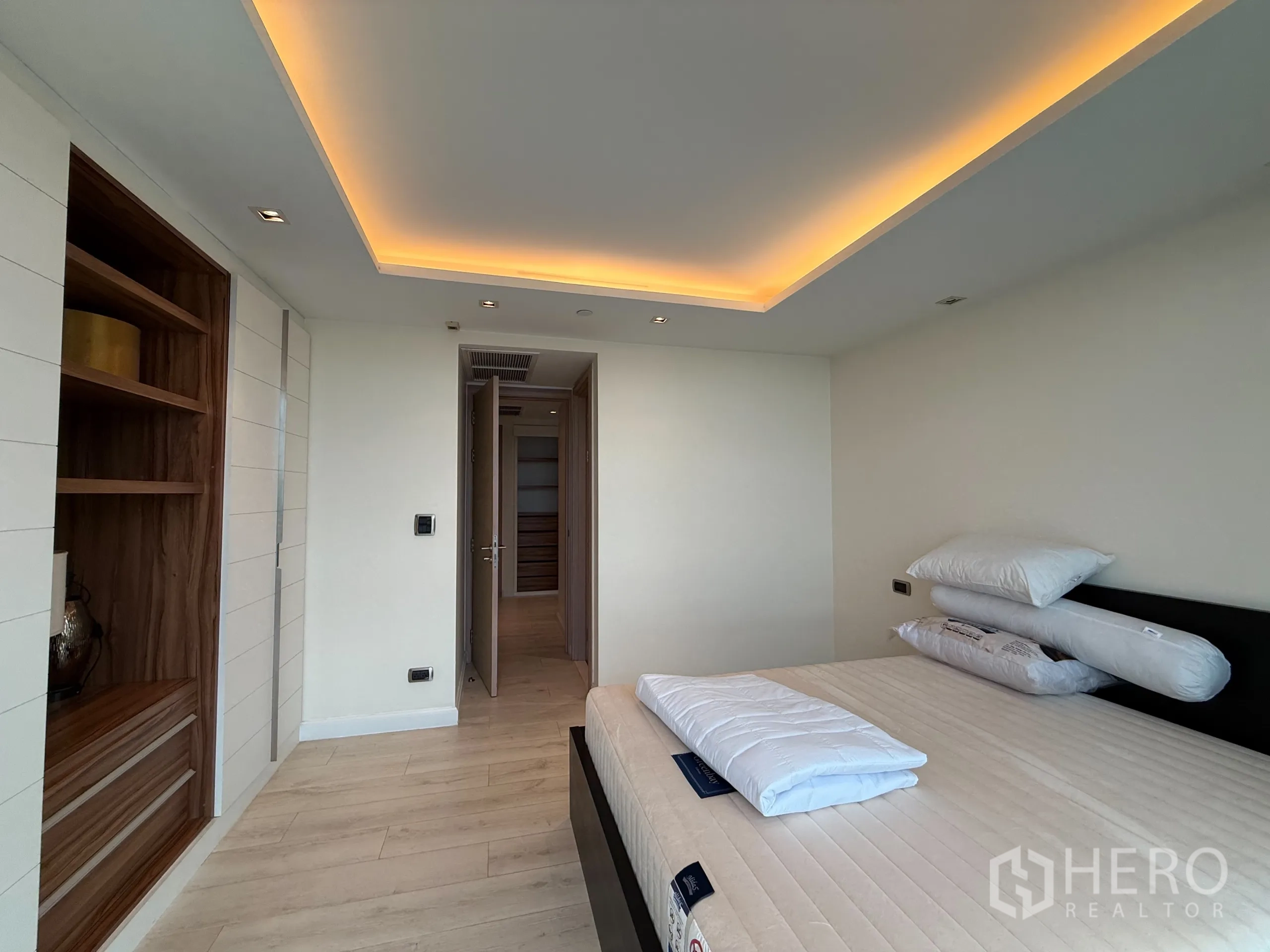Condominium for rent in Phaya Thai, Bangkok - Reverse angle of bedroom showing cove lighting and built‑in wardrobe system.