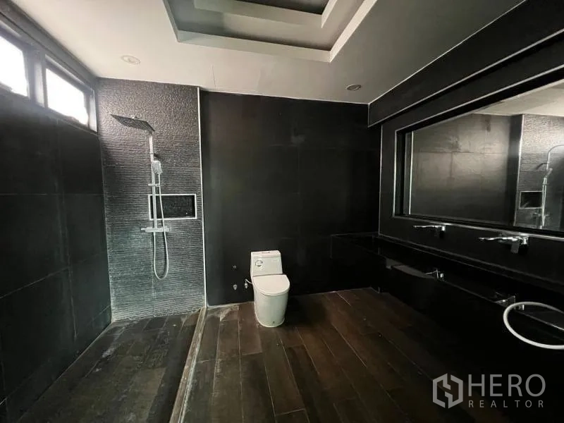 独立式住宅 出售在Lat Phrao, Bangkok - 现代深色调浴室，雨淋花洒、长台盆与大镜面。