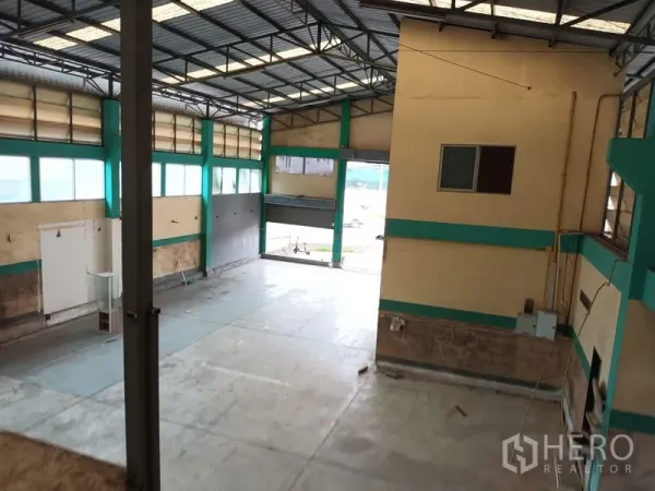 Warehouse for rent in Phasi Charoen, Bangkok - View from mezzanine over open floor and wide roller shutter loading entrance.